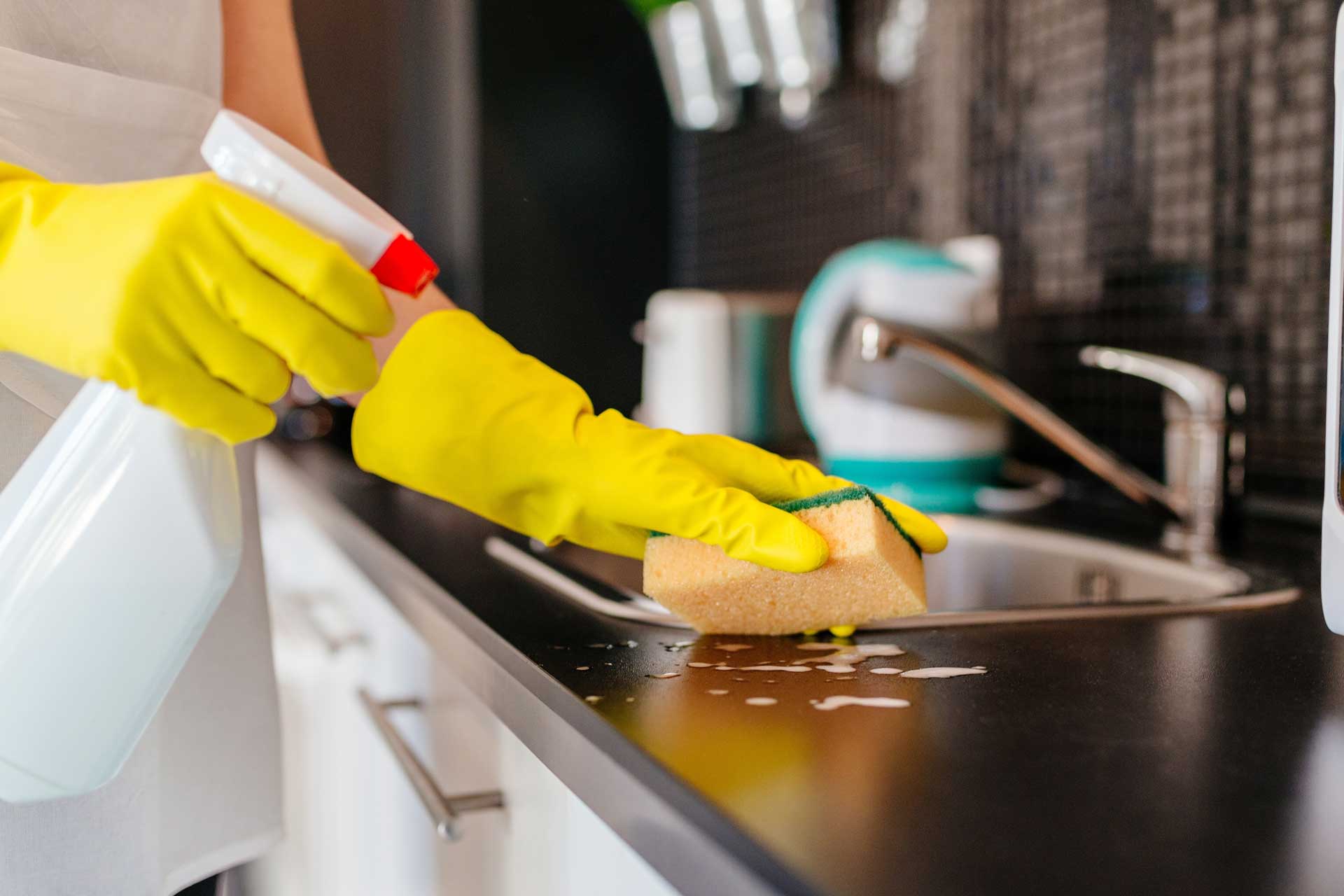 cleaning with sponge near sink in kitchen